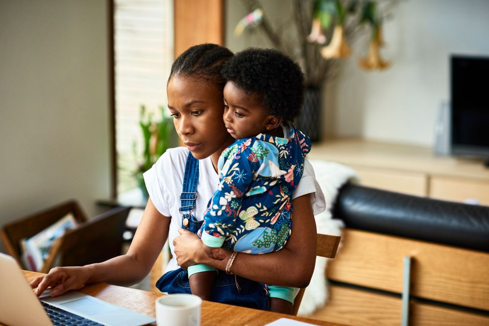 Mother working on a laptop with her child