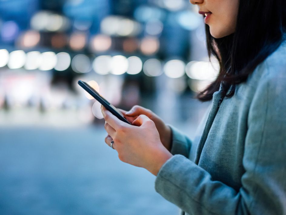 Woman on phone checking her investments