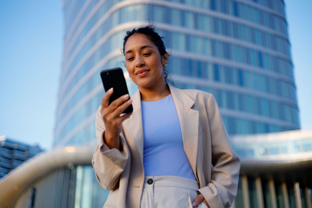 Lady wearing a blue top looking at her phone