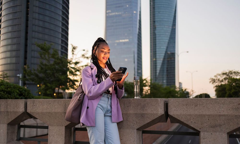 lady in wearing a purple blazer looking at her phone