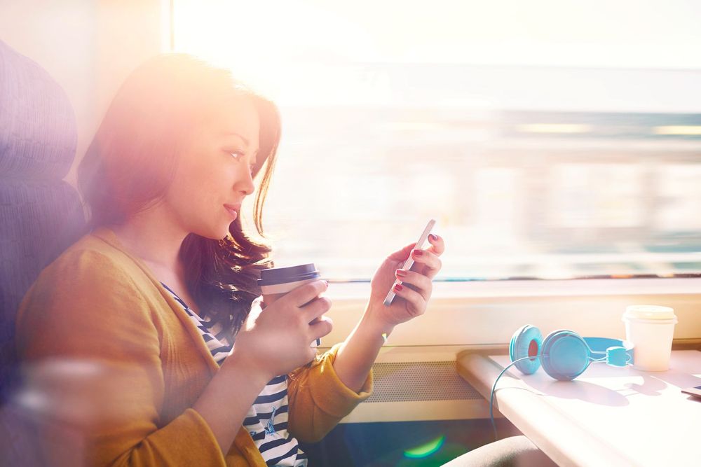 Woman looking at phone while travelling by train 
